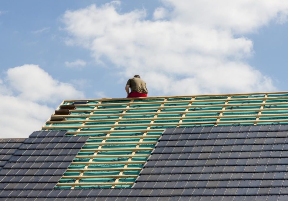 a man on the roof installing tile roof